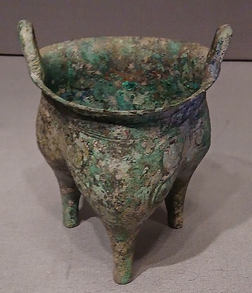 袋状の三本足に象文を飾った青銅の鬲(東京国立博物館蔵)