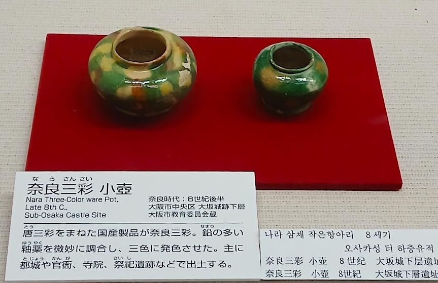 大阪歴史博物館に展示されている奈良三彩の小壺。緑・褐色・白の釉薬がかかっている